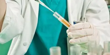 A person holding a syringe in their hand.