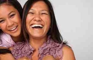 Two women laughing and smiling together.