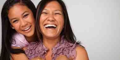 Two women laughing and smiling together.