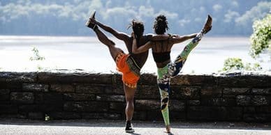 Two people doing different poses on a beach.