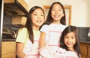 Three girls in white shirts and yellow aprons.